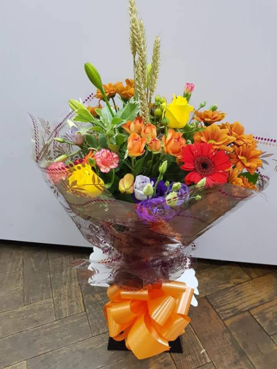 Sunset Symphony - A vibrant bouquet of peach, sunshine yellow, coral-red, and rich purple blooms, capturing the warmth and beauty of a summer sunset