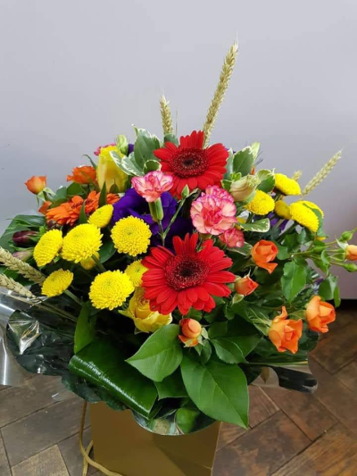 Golden Joy - A stunning arrangement of vibrant red, sunny yellow, soft peach, and rich purple blooms, beautifully combined to create a bouquet full of warmth, joy, and elegance. Inspired by the colors of a glowing sunset, this eye-catching design is perfect for celebr