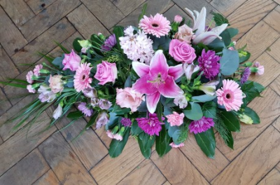 Single ended Spray - A beautiful funeral spray arranged in soft pink and rich purple tones, creating an elegant and heartfelt floral tribute.