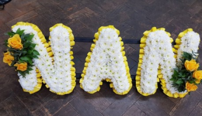Yellow Nan Tribute - White Chrysanthemums with yellow Roses and mixed foliage letter tribute.
